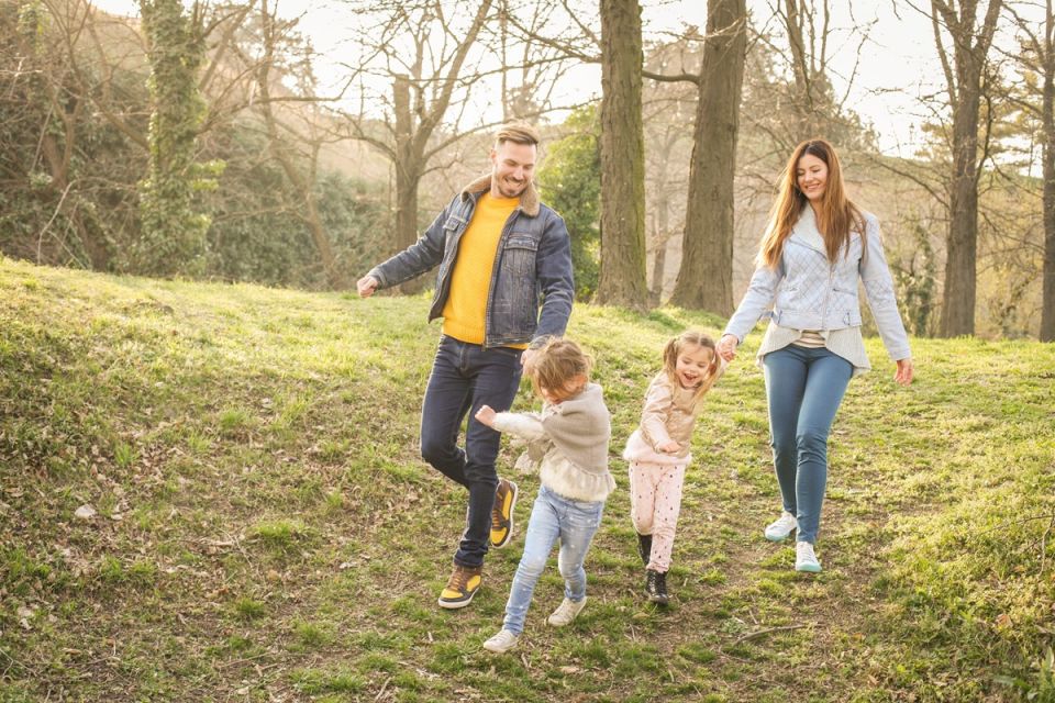 young family running in the woods